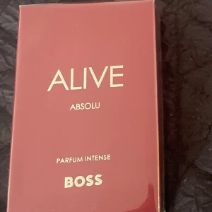 Alive Absolu Parfum Intense från Boss - Alive Absolu Parfum Intense från Boss kommer i en elegant vinröd förpackning. Denna doft är intensiv och perfekt för den som vill ha något extra. Förpackningen har en stilren design med guldtext som ger en lyxig känsla.