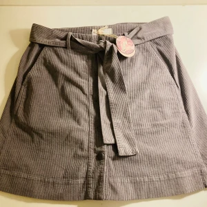 Grå manchesterkjol från Odd Molly - Säljer en snygg grå manchesterkjol från Odd Molly. Kjolen har ett knytband i midjan och praktiska fickor på sidorna. Perfekt för en stilren look. 🖤