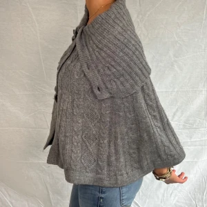 Grå stickad poncho med knappar - Super fin stickad grå poncho, med fina detaljer. Funkar till det mesta!🤩😍stolek Xs