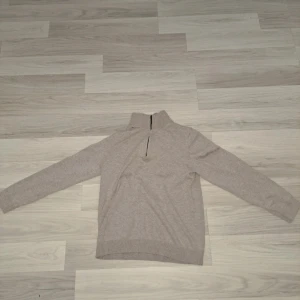 Beige tröja med dragkedja från MNG - Säljer en stilren beige tröja från MNG med dragkedja vid halsen. Tröjan har långa ärmar och är perfekt för kyligare dagar. Den är tillverkad i ett mjukt material som ger en bekväm passform.