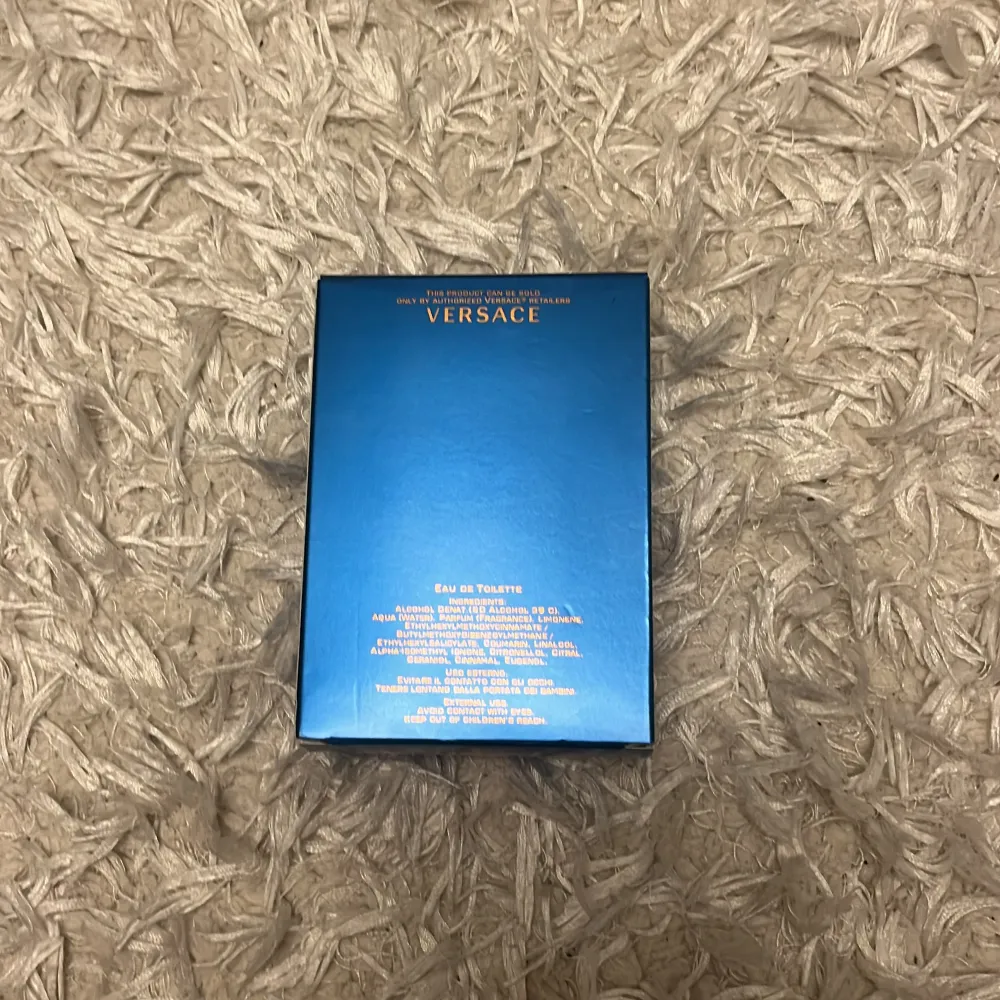Säljer en flaska Versace Eros Eau de Toilette, 100 ml. Flaskan har en elegant design med ett svart mönster och blå detaljer. Förpackningen är i en stilren blå färg med Versace-loggan i guld. Perfekt för den som vill ha en fräsch och maskulin doft. Är sprutad typ 10 gånger.. Perfume.