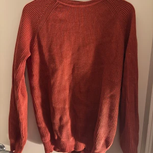 Rostfärgad tröja från John Henric - Säljer en snygg rostfärgad tröja från John Henric. Tröjan är ribbad och har långa ärmar, perfekt för kyligare dagar. Den är i storlek M och passar bra till både vardag och mer uppklädda tillfällen.