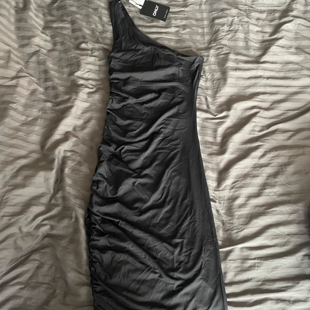 Snygg grå klänning med en tight passform. Perfekt för en elegant kvällslook. Klänningen har en stilren design som framhäver figuren. Går att ha på två sätt. Mekot.