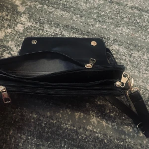 Svart Axel väska från Guess - Snygg svart axelväska från Guess i mycket bra skick. 