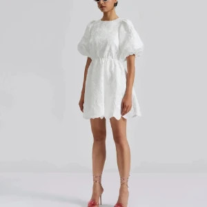 Vit klänning med puffärmar - Säljer min fina studentklänning med puffiga kortärmar och en öppen rygg. Klänningen har en fin struktur och är perfekt för sommarens student/skolavslutning! Använd endast på studentdagen, (lånade bilder) ❤️