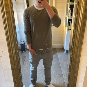 Lindbergh tröja - Säljer en enkel grå grön stickad tröja med rund halsringning. Tröjan har långa ärmar och en klassisk passform. Perfekt för lager-på-lager och passar till det mesta i garderoben. Storlek s. Ny pris ca 800