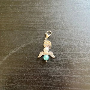 Ängelberlock med pärlor och vingar🩵 - Söt berlock i form av en ängel med silverfärgade detaljer, vita och turkosa pärlor samt små vingar. Perfekt som accessoar till halsband, armband eller väska.🩵