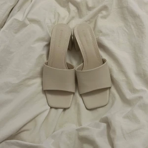Krämvita sandaler från Stradivarius - Ett par jättefina krämvita sandaler med ca 6cm hög klack. Dessa är köpta för ett par år sen men bara använda en gång och är i väldigt bra skick🤍🥂