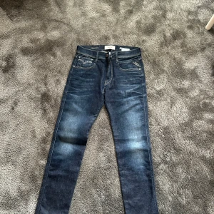 Replay Hyperflex Anbass jeans - Mörkblå jeans från Replay, modell Hyperflex Anbass. Klassisk femficksdesign med snygga kontrastsömmar och läderpatch bak i midjan. Jeansen har en rak passform och är tillverkade i stretchigt denim för extra komfort.  L34 W31