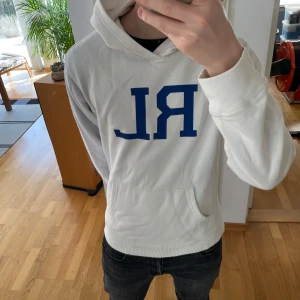Ralph Lauren Hoodie - Säljer en unik vit hoodie från Ralph Lauren. Hoodien är i väldigt bra skick även fodret inuti är fortfarande mjukt och fluffigt. Sjukt trendig just nu och sitter i strl M. Hör gärna av er vid frågor eller funderingar!!