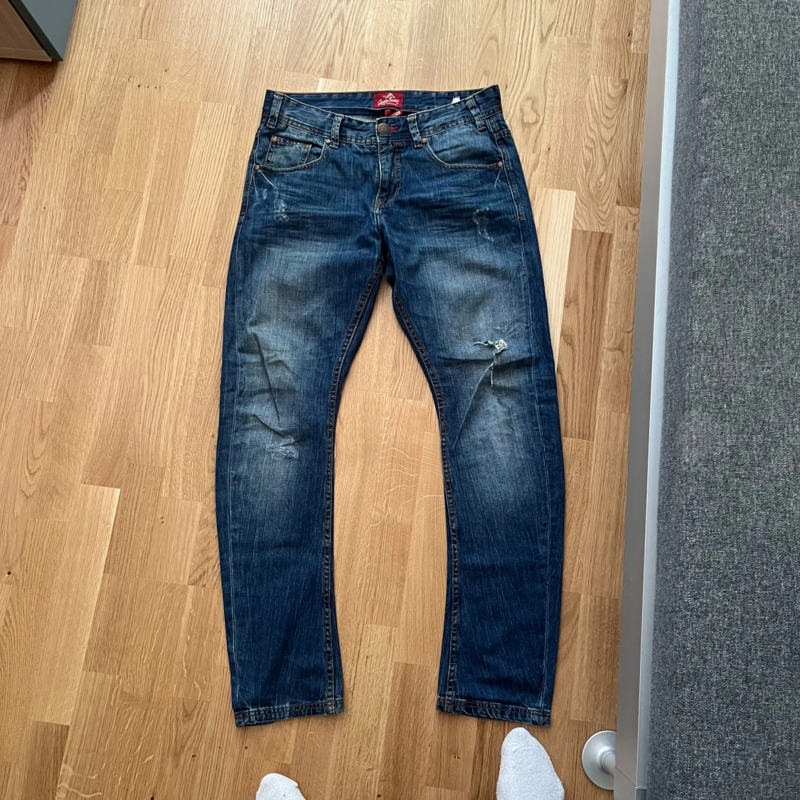Blå jeans med slitningar