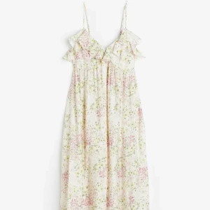 Blommig sommarklänning med volang - Söt långklänning med smala axelband och volangdetalj upptill. Klänningen har ett blommigt mönster i ljusa toner av rosa, grön och gul på vit botten. Perfekt för varma dagar och midsommarfirande. Saknar lapp skulle gissa på storlek M! Aldrig använd 💕säljs inte längre 