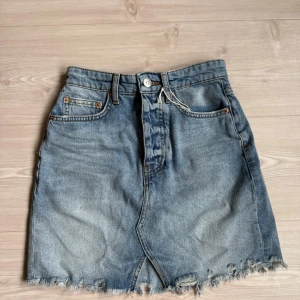 Blå jeanskjol - Säljer en blå jeanskjol i storlek 32 från Ginatricot. Aldrig använd endast testad. 