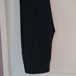 Stiliga svarta kostymbyxor från Gina Tricot! - Stilrena svarta kostymbyxor från Gina Tricot. Dragkedja, knapp och fickor. Perfekta för en clean och dressad look.