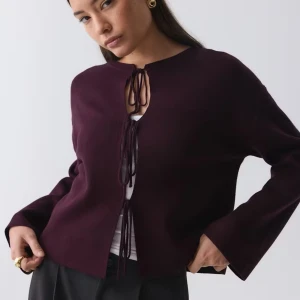 Slutsåld Vinröd kofta - Säljer en vinröd cardigan med knyt framtill. Koftan har lång ärm och en rak, lite loose passform. Perfekt att slänga över en topp för en snygg lager-på-lager-look. Slutsåld på hemsidan!