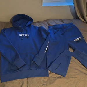Blå hoodie från Hoodrich - Säljer en blå hoodie från Hoodrich i storlek XS. Tröjan har huva med dragsko, ribbade muddar och tryckt logga både fram och bak. Perfekt för en avslappnad och sportig stil.