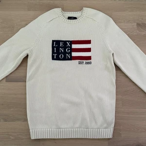 Vit stickad tröja från Lexington - Vit stilren stickad tröja från Lexington. Rund halsringning och ribbade muddar vid ärmslut och nederkant. Perfekt för en stilren look. Strlk M. Nyskick