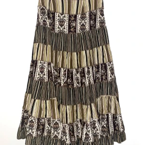 Mönstrad volangkjol - Bohemisk kjol med mönster i bruna, gröna och beige toner. Tillverkad i ett mjukt tyg med volang och dragkedja i sidan. 