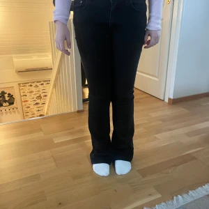 Svarta bootcut jeans - Snygga svarta jeans med bootcut-modell och klassisk femficksdesign. Byxorna har hög midja och raka ben som blir vidare nertill. Perfekta för en stilren och trendig look.