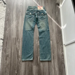 True Religion Jeans (W28)  - Säljer det True Religion Straight Jeans.  Många intresserade redan, så först till kvarn! Skicka DM eller köp direkt via annonsen. (Storlek:W28, Midjemått:34-35cm, Byxlängd:106cm, Innerbenslängd:80cm) 