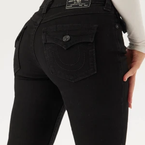 Svarta bootcut jeans från True Religion - Säljer ett par svarta jeans från True Religion med klassiska fickdetaljer och synliga sömmar. Köpte dessa i julas men säljer nu får att de är för små, jag är 160 och de är lite långa i längden. Skulle tipsa dessa till någon som har midjemåttet 23-24💕                                                                      De är heltslutsålda och är ganska svåra att få tag i då de inte sälj lika ofta som de andra true religion jeansen💕 nypris 1300kr