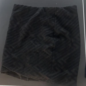 Svart manchester minikjol - Snygg svart kortkjol i manchester med diskret mönster. Kjolen har en rak passform och känns både trendig och enkel att matcha med olika stilar. Perfekt för dig som gillar en stilren look med lite edge.skriv för fler bilder 