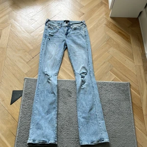 True Religion Becca - Snygga ljusblå bootcut jeans från True Religion, modell Becca Mid Rise. Jeansen har slitna detaljer på benen, röda kontrastsömmar och ikoniska bakfickor med lock och knapp. Tillverkade i klassisk denim med cool vintagekänsl. Säljer eftersom de är för stora på mig men de är använda fåtal gånger så de är i princip nya, Pris kan diskuteras vid snabb affär💞
