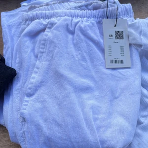 Linnebyxor  - Vita mjukisbyxor från 57 i storlek XS. Byxorna har resår i midjan och är tillverkade i mjuk bomull, perfekta för en chill och avslappnad stil. Snygg och enkel design med fickor på sidorna.