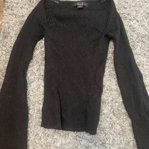 Svart ribbad stickad tröja Amisu XS - Säljer en svart, ribbad och figurnära stickad tröja från Amisu i storlek XS. Tröjan har lång ärm och en snygg, något bredare halsringning. Perfekt att styla med jeans eller kjol för en clean look. Endast testad