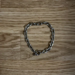 Stilrent kedjearmband i silverfärg - Tungt och stilrent armband i metall med klassisk kedjedesign. Perfekt accessoar för att ge din outfit en clean och edgy touch. Passar både killar och tjejer. Användbart till både streetwear och mer uppklädda looks.  🟪 Färg: Silver 🟪 Material: Metall 🟪 Passform: Passar de flesta handleder  🟪 Skick: Mycket bra – knappt använt.        