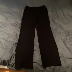 Svarta slim straight  byxor från Vero Moda - Svarta byxor från Vero Moda i modellen Zamira MR Slim. De har rak passform med midwaist och är tillverkade i ett mjukt, stretchigt material som sitter snyggt. Perfekta till en clean och stilren look.