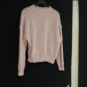 Ljusrosa stickad tröja från Dazy - Supermjuk ljusrosa stickad tröja från Dazy med relaxed fit och ribbade muddar vid hals, ärmslut och nederkant. Perfekt för lager-på-lager och chill dagar. Enkel och stilren design som är lätt att matcha med jeans eller kjol.