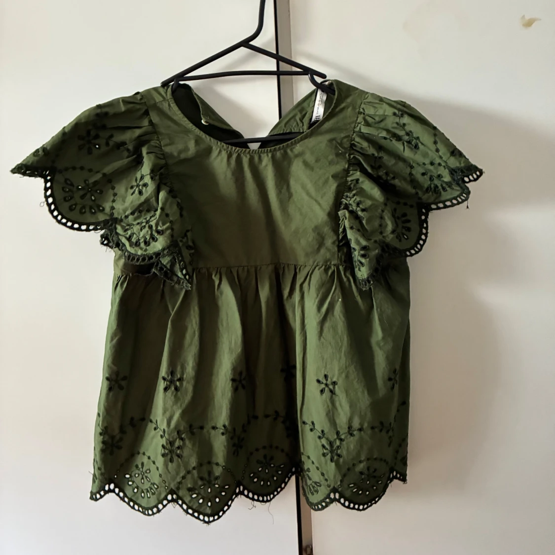 Grön blus med broderade volangärmar