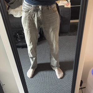 Grå jeans från Weekday straight fit - Säljer ett par grå jeans från Weekday med klassisk femficksdesign och raka ben. Jeansen har normal passform och är tillverkade i bomull. Perfekta för dig som gillar en enkel och clean look.