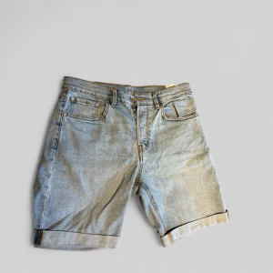 Ljusblå jeansshorts från vailent - Snygga ljusblå jeansshorts med klassisk femficksdesign och uppvikta benslut. Shortsen har bälteshällor och dragkedja med knapp framtill. Perfekta för varma dagar när du vill ha en avslappnad och stilren look.