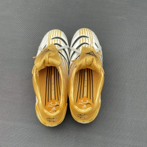 Adidas Predator fotbollsskor i vitt och guld - Säljer ett par Adidas Predator fotbollsskor i vitt och guld med svarta detaljer. Skorna har snörning och klassisk rund tå, samt mönstrad sula för bra grepp på planen. Perfekta för dig som vill sticka ut på fotbollsplanen! Säljs pga att jag inte hår på mig dem längre. Inga skador på dem. Pris kan diskuteras 😃
