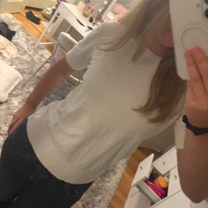 Vit stickad t-shirt - Enkel och stilren vit t-shirt i lite tjockare stickat material. Modellen är klassisk med rund halsringning och korta ärmar. Perfekt att matcha med jeans eller shorts för en clean look. T-shirten har en normal passform och är superbekväm att bära.