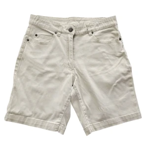 Beige klassiska jeansshorts - Stilrena beige shorts i klassisk jeansmodell från Isolde med fem fickor, bälteshällor och knappstängning. Perfekta för varma dagar och enkla att matcha med allt. Materialet är mjukt och skönt bomullstyg som ger en avslappnad vibe.