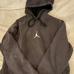 Jordan Hoodie mörkgrå - Mörkgrå hoodie från Jordan med den klassiska loggan på bröstet. Storlek M. Prislappen har tagits bort men tröjan har aldrig använts mer än när jag testa den första gången. Det var en present och jag bär S så tyckte den var för stor. Väldigt skön och ha på sig, tror den kostar runt 6-700kr ny, tveka inte att höra av er vid frågor och intresse! 
