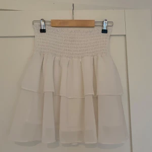 Vit volangkjol från Chelsea XS - Supersöt vit kortkjol med volanger från Chelsea 