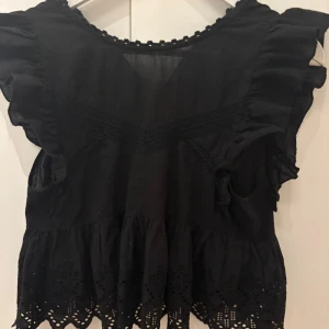 Svart blus med volang och broderade detaljer - Svart jätte söt blus från Zara. Den har används men har ingen slitage alls💕