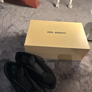  Axel Arigato laceless svart - Säljer ett par svarta Arigato Laceless – i princip som nya! Endast använda ett fåtal gånger, inga skador eller märken. Stilrena, bekväma och perfekta inför sommaren. Nypris över 2000 kr – du får dem för ett riktigt kap. Skicka vid intresse!