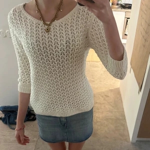 Vit stickad tröja med mönster - Säljer en vit virkad tröja med fint hålmönster och rund halsringning. Tröjan har trekvartsärm och är perfekt för lager-på-lager. Passar till både jeans och kjol.
