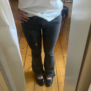 Grå/svarta bootcut jeans - Säljer ett par grå/svarta bootcut jeans från Gina Tricot med medelhög midja. Suupersköna då de har ett liite stretchigare jeansmaterial! Lite slitna längst eftersom de är för långa på mig som är 159cm💕
