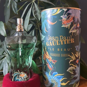 Jean Paul Gaultier Le Beau Paradise Garden - Parfymen Le Beau Paradise Garden från Jean Paul Gaultier i en unik flaska formad som en manlig torso med grön vätska och broderad lövdetalj. Kommer i en dekorativ grön tub med färgglada blommor och drakmotiv. Volym: 125 ml varav 100 ml återstår. Eau de Parfum.