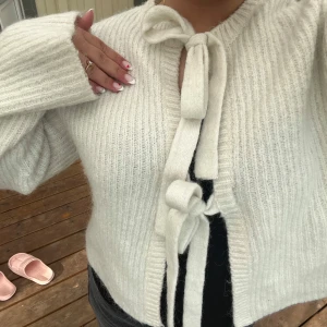 söt kofta med rosetter  - Supermysig vit stickad kofta med rosetter fram. Finns inte längre på ginas hemsida🩷