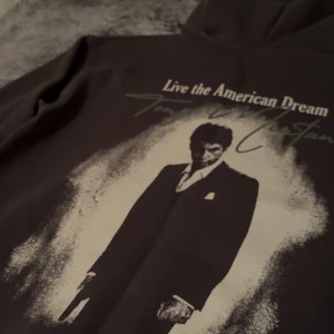 Grå Scarface hoodie med tryck - Exklusiv Hoddie köpt i Spanien 🇪🇸.Grå hoodie med stor Scarface-tryck på baksidan och texten 'Live the American Dream'. Perfekt för dem som har klass och gillar sig en stilren look🤩✅(hoodien är XS men passar S/M👌)!!