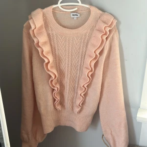 Ljusrosa stickad tröja med volang - Superfin ljusrosa stickad tröja från Bubbelroom med volanger. Storlek M men skulle tolka den som en S. 