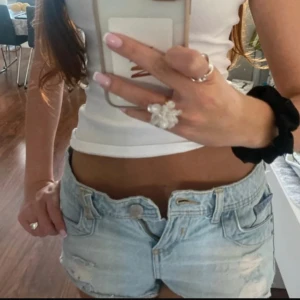 Ljusblå jeansshorts med Union Jack-detaljer - Säljer ett par ljusblå jeansshorts med låg midja och råa kanter. Shortsen har slitna detaljer framtill. Perfekta för sommaren och ger en cool, edgy vibe. Inte använt!! 🥰