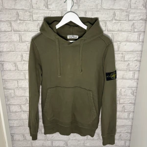 Stone Island hoodie - Snygg olivgrön hoodie från Stone Island. Klassisk modell med huva, ficka och patch på ärmen. I mycket fint skick utan fläckar eller hål, använd enstaka gång. Hör av dig vid intresse 🙌
